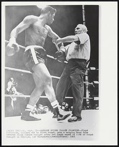 Referee Guides Fallen Champion-- Floyd Patterson, knocked out in first round, gets a helping hand from referee Frank Sikora tonight after ten count ended 2:06 of round tonight in Chicago.