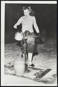 Hot Water for Near Zero Weather--Pretty 17-year-old high school senior, Nancy Jean Chrisman of Creve Coeur, five miles south of Peoria, Ill., uses a tea kettle of boiling water to thaw out the water pump at her home in near zero weather.