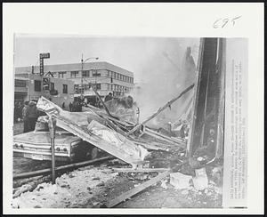 Cars Crushed in Earthquake--Automobiles parked on Fifth Avenue in downtown Anchorage were crushed when walls of the five-story J.C. Penney Co. building sheared away during major earthquake.