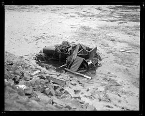 Damaged car in mud, possibly after a flood