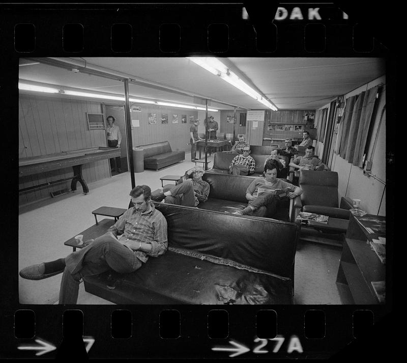 Men read and play pool in recreation hall, North Slope camp, Anchorage, Alaska