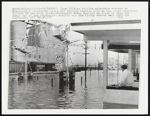 A filling station attendant watches as Mississippi floodwaters cover his filling station 4/25 as the river continues to rise at the Rock Island-Davenport area. Earlier he tried to keep the water out of the sandbagged station but the rising water went over the barricade.