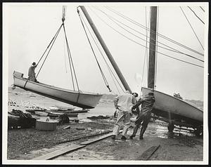 Boatyard workers haul craft ashore in Marblehead.