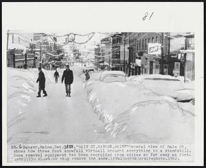 Bangor, Maine. "Main St, Bangor, Maine" General view of Main St, shows how three foot snowfall virtually brought everything to a standstill. Snow removal equipment has been recruited from cities as far away as Portland, (150 miles) to help remove the snow.