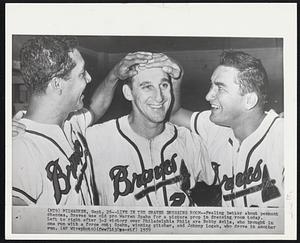 Life in the Braves Dressing Room--Feeling better about pennant chances, Braves use old pro Warren Spahn for a picture prop in dressing room today. Left to right after 3-2 victory over Philadelphia Phils are Bobby Avila, who brought in one run with a force out; Spahn, winning pitcher, and Johnny Logan, who drove in another run.