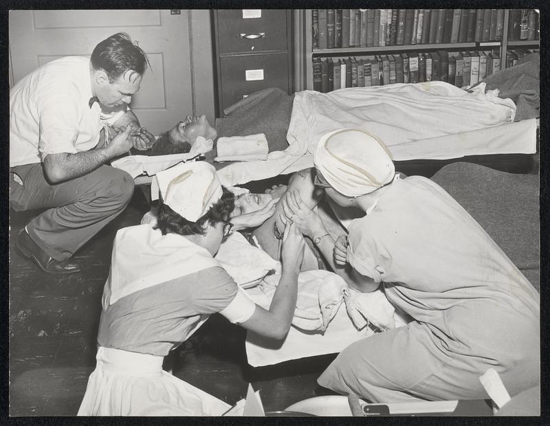 Weather-Tornados-Worcester County. A Doctor and Two Nurses Administer Aid to Two Victims of the Twister in a Hastily-Established Emergency Room.