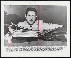 Santee's Ready--America's top miler, Wes Santee, looks over legal papers in hotel here today. Judge Charles D. Breitel ruled today that Santee was eligible to compete in tonight's Knights of Columbus track meet at Madison Square Garden. He had been suspended by the Amateur Athletic Union on charges of having accepted excessive expenses.