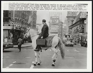 New York: With strikebound traffic in New York almost at a stand-still salesman Bert Alexander uses a horse to make his rounds in midtown Manhattan 1/7. After the Transit Authority refused to request the release of the jailed Transport Workers Union leaders and asked court to fine the union $322,000 daily, quick settlement seemed remote.