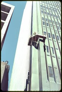 Men going up the side of a building on a platform