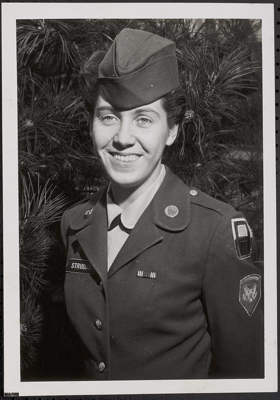 "WAC of the month" for December 1963, Sp5 Eleanor M. Strudas in front of the Guest Houses at Fort Hamilton, Brooklyn, N.Y.