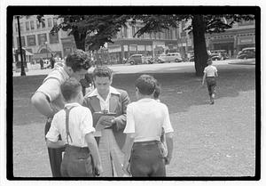 People surround a man holding a clipboard