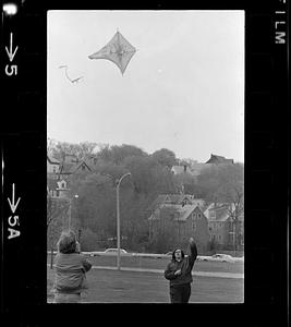 Teen boys play with kites by Charles River, Boston
