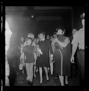 Judy Garland and son Joey Luft walking through crowd after arriving in Boston