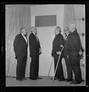 Mayor John F. Collins, third from right, standing under Boston Opera Association plaque at the War Memorial Auditorium with four other men