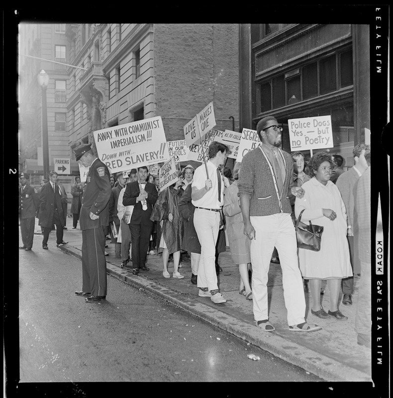 Protesters with signs marching outside of School Committee headquarters