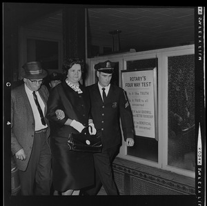 Louise Day Hicks leaving Boston School Committee meeting escorted by Sgt. John Hames and unidentified police officer