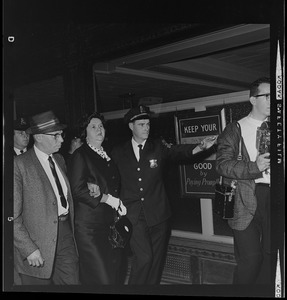 Louise Day Hicks leaving Boston School Committee meeting escorted by Sgt. John Hames and unidentified police officer
