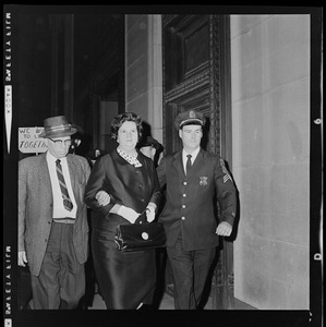 Louise Day Hicks leaving Boston School Committee meeting escorted by Sgt. John Hames and unidentified police officer