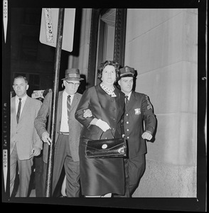 Louise Day Hicks leaving Boston School Committee meeting escorted by Sgt. John Hames and unidentified police officer