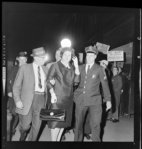 Louise Day Hicks escorted by Sgt. John Hames and unidentified police officers through protest against school segregation outside Boston School Committee meeting