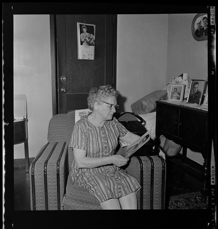 Woman looking at portrait photograph of younger man