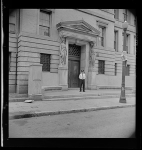 Police officer standing outside entrance to unidentified school