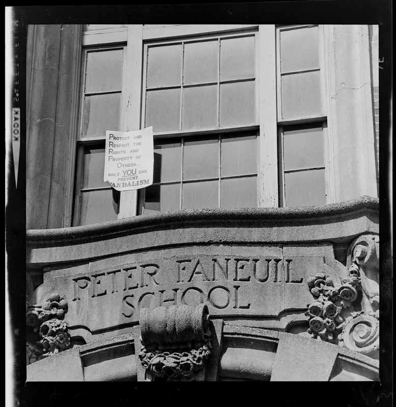 Sign about preventing vandalism above entrance of Peter Faneuil School