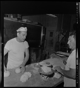 Two bakers making dough