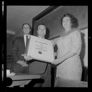 Kevin Finnegan, 21, of Lowell, left, and Robert McNulty, 22, of Quincy, president of the Young Democrats of Boston College, presents Louise Day Hicks, candidate for Mayor of Boston, the Woman of the Year award