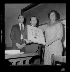 Kevin Finnegan, 21, of Lowell, left, and Robert McNulty, 22, of Quincy, president of the Young Democrats of Boston College, presents Louise Day Hicks, candidate for Mayor of Boston, the Woman of the Year award