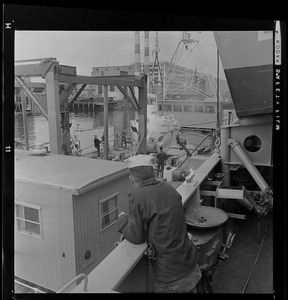 Sailor watching as miniature submarine Alvin is hoisted from the U.S.S. San Marcos