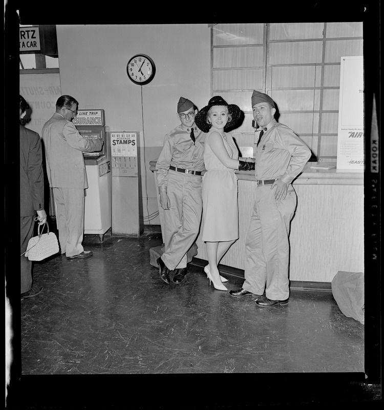 Film actress Zsa Zsa Gabor makes herself comfortable at Logan Airport after arriving in Boston for visit. First to spot her were GIs Steven Weiner, Dorchester and Stephen Avslander, Brookline, who wait as Zsa Zsa gives her autograph