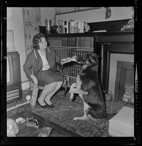 Mrs. Louise Day Hicks receives a copy of the Record American and the good news from her pet Prinz at her home