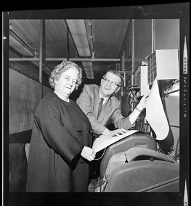 Unidentified woman and man at teletype machine