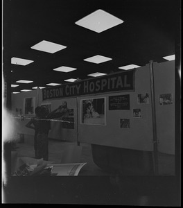 Man and woman setting up a Boston City Hospital exhibit for the opening of the War Memorial Auditorium
