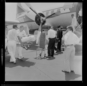 Marvella Hern Bayh removed from ambulance in front of the Kennedy family plane "Caroline"