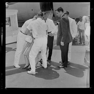 Marvella Hern Bayh in upright stretcher being carried onto the Kennedy family plane "Caroline"