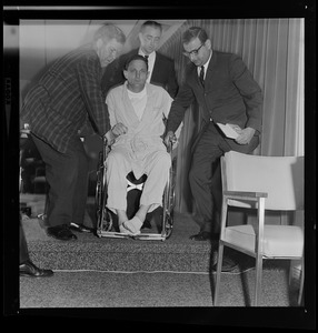 Dr. David Jackson and two unidentified men with Senator Birch Bayh in wheelchair for press conference