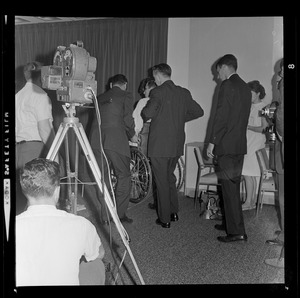 Men lifting Senator Birch Bayh in wheelchair at press conference
