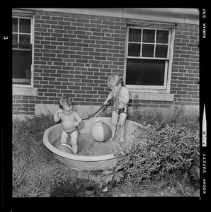 Two children playing in a wading pool