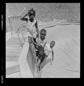 Three children at empty above-ground pool