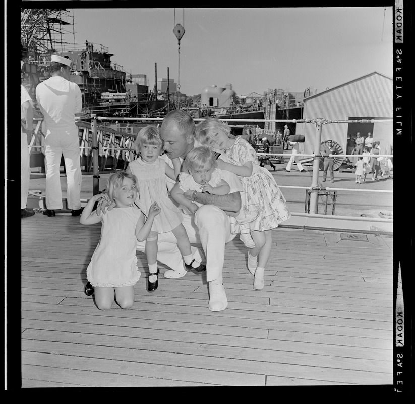 Sailor hugging four children after the USS Boston returns to Boston Naval Shipyard from training cruise