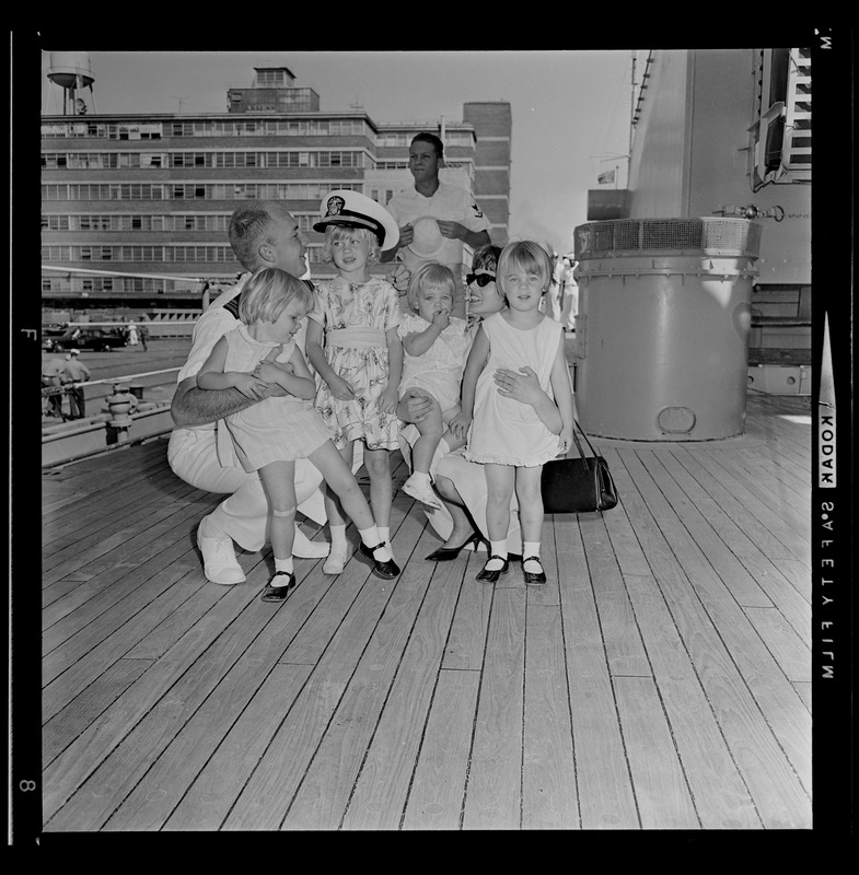 Sailor reuniting with woman and four children after the USS Boston returns to Boston Naval Shipyard from training cruise