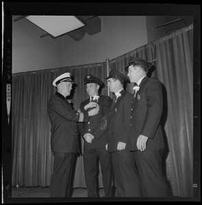Boston Fire Department Chief William Terrenzi congratulates Department honor medal winners during 87th Annual Firemen's Ball at War Memorial Auditorium. From left are Chief Terrenzi, Firefighters Henry Miller, Arthur Glover, and Charles Stokinger
