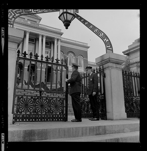 Two officers standing at the gates of the State House during UMass Boston protest