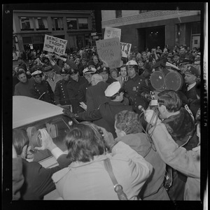 Dr. Benjamin Spock surrounded by protesters outside the Federal Building in Boston after his arraignment on charges of aiding draft resisters