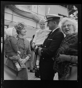 Unidentified Navy officer with unidentified women and children after arrival of USS Boston at South Boston Naval Annex