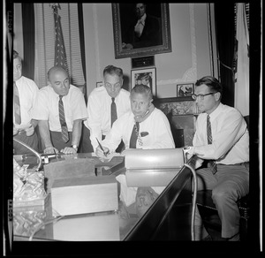 Gov. John A. Volpe, on phone at the State House, checks conditions in Springfield as aides (L. to R.) A. DeFalco, J. Tauro, T. Regan, and Lt. Gov. E. Richardson stand by