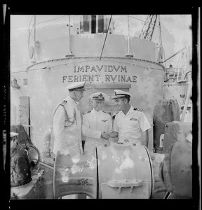 Three crew members on the ship deck of the Italian missile destroyer Impavido