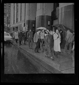 Pickets sympathetic with Dr. Spock and other defendants march outside Boston's Federal Building